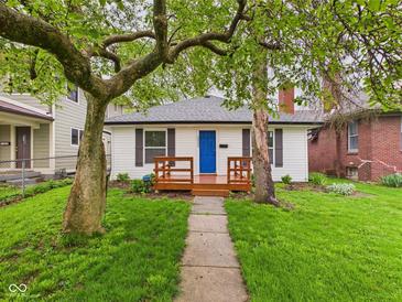 Charming home featuring a vibrant blue front door and a cozy wood porch at 3559 Carrollton Ave, Indianapolis, IN 46205