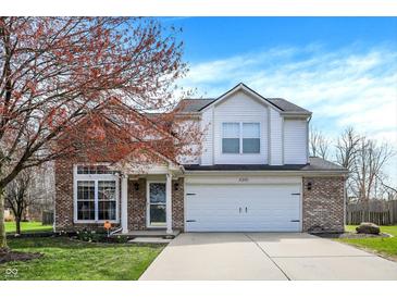 Charming two-story home boasts brick and white siding, attached two-car garage and well-manicured lawn at 4345 Elkhorn Dr, Westfield, IN 46062