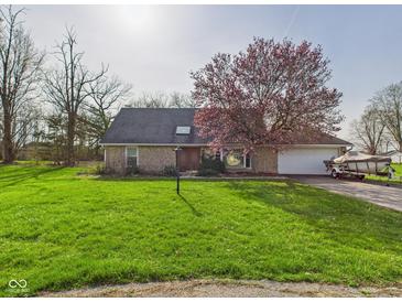 Charming brick home boasts a lush front yard and attached two-car garage at 6413 N Wheeling Ave, Muncie, IN 47304