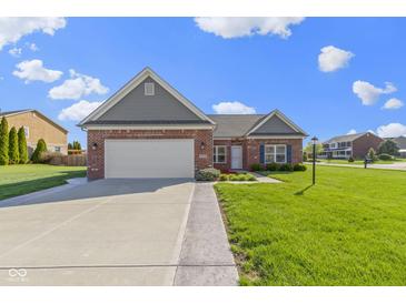 Charming brick home features a well-maintained lawn and attached two-car garage at 6524 Turf Way, Anderson, IN 46013
