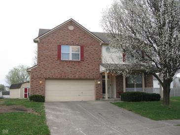 Two-story brick home with an attached two-car garage and flowering tree in front at 10762 Galant Fox Ct, Indianapolis, IN 46234