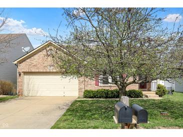 Charming brick home featuring an attached two-car garage and a well-maintained front yard at 12404 Rose Haven Dr, Indianapolis, IN 46235