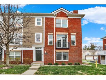 Inviting townhome features a classic brick facade, lush lawn, and well-maintained landscaping at 253 1St Nw St, Carmel, IN 46032