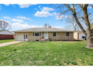 Charming single-story home with a well-manicured lawn and stone facade, set against a blue sky at 318 Winfield St, Greenfield, IN 46140