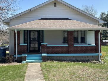 Charming single-Gathering home featuring a covered porch with brick columns and freshly painted trim at 359 N Whitcomb Ave, Indianapolis, IN 46224