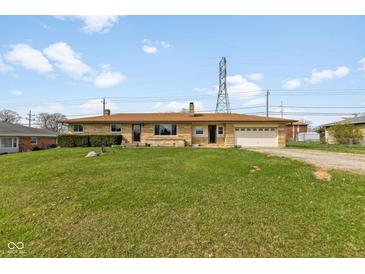 Charming single-story home with a stone facade, attached garage, and spacious front lawn at 3638 Redfern Dr, Indianapolis, IN 46237