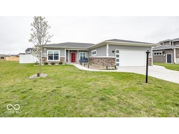 Charming home featuring grey siding, stone accents, a red front door, and a well-manicured lawn at 694 N Sobota Way, Trafalgar, IN 46181