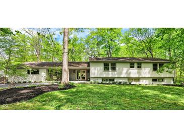 Charming home featuring a well-manicured lawn and beautiful landscaping, complemented by a tree-lined property at 8990 Pickwick Dr, Indianapolis, IN 46260