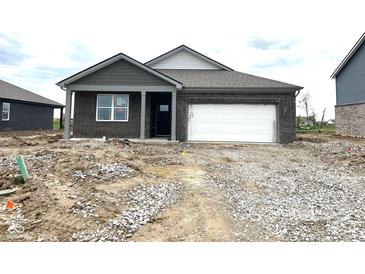 New single-story home featuring a brick facade and attached garage; exterior is awaiting final landscaping at 915 Saddlebrook Farms Blvd, Whiteland, IN 46184