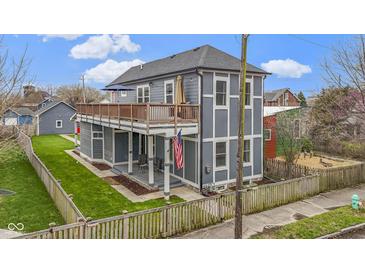 Charming two-story home features a spacious deck, fenced yard, and welcoming front porch, perfect for relaxing outdoors at 953 Harrison St, Indianapolis, IN 46202