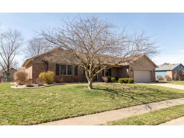 A charming, single story brick home featuring an attached garage, lawn, and mature trees at 1002 Corey Ln, Plainfield, IN 46168