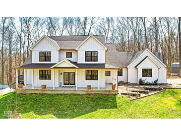Charming white two-story home with inviting front porch and black trimmed windows on a green lawn at 1037 E Woodall Ct, Martinsville, IN 46151
