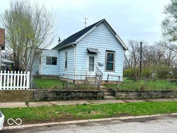 Quaint single-Gathering home with a light blue exterior and a small, fenced-in front yard at 1237 N Sheffield Ave, Indianapolis, IN 46222
