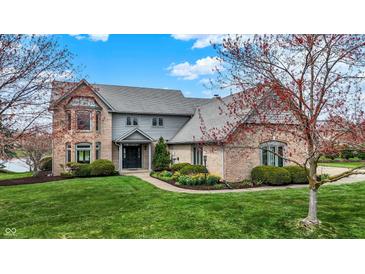 Beautiful brick two-story home boasts mature trees, well-kept lawn and manicured landscaping at 12535 Glendurgan Dr, Carmel, IN 46032
