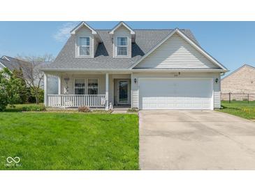 Charming two-story home with a cozy front porch and a well-maintained lawn, featuring a two-car garage at 329 Dogwood Dr, Pendleton, IN 46064