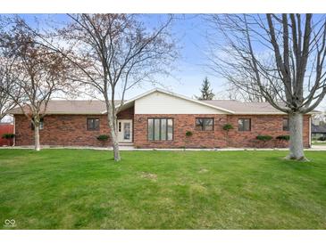 Charming brick ranch home with a well-manicured lawn and mature trees at 4411 W Friar Dr, Muncie, IN 47304