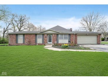 Charming one-story brick home with a well-manicured lawn and attached two-car garage at 5061 Sylvan Rd, Indianapolis, IN 46228