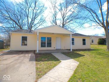 Inviting single-story home features a cheerful yellow exterior with a covered front porch and well-maintained lawn at 5523 Epperson Ct, Indianapolis, IN 46221