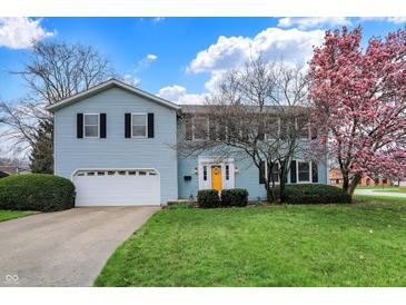 Charming two-story home with blue siding, yellow front door and an attached two car garage at 1716 Teakwood Ct, Lafayette, IN 47905