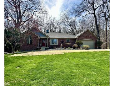 Charming brick ranch-style home with a well-manicured lawn and mature trees creates a welcoming curb appeal at 2143 Sunderland Dr, Martinsville, IN 46151