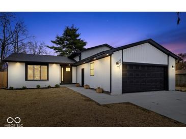 Charming home featuring modern black and white accents, attached garage, and well-manicured lawn at 4921 Cottonwood N Ct, Columbus, IN 47203