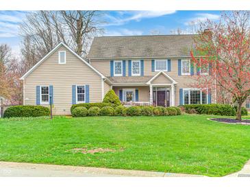 Charming two-story home featuring blue shutters, manicured lawn, and lovely landscaping at 7002 Oakbay Cir, Noblesville, IN 46062