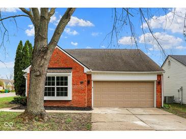 Charming brick home with a two-car garage and well-maintained landscaping at 7783 Park N Ct, Indianapolis, IN 46260