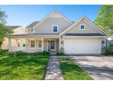 Charming two-story home with a covered porch, attached garage, and a well-manicured lawn at 9705 Shasta Dr, Fishers, IN 46038