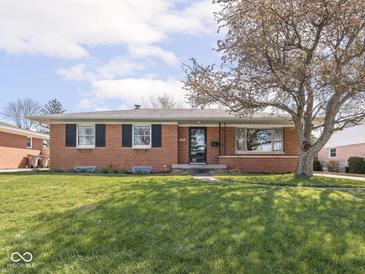 Charming brick home with a well-maintained lawn and large shade tree at 1035 N Audubon Rd, Indianapolis, IN 46219