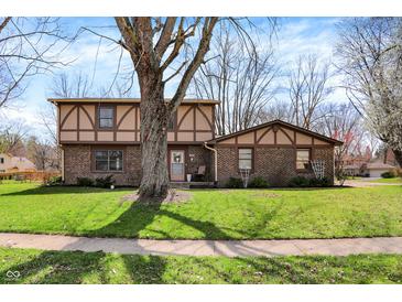 Charming two-story brick home with Tudor-style accents and a well-manicured lawn at 1123 Woodbridge Ln, Indianapolis, IN 46260