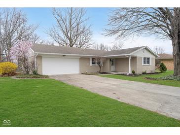 Front exterior view of a brick home with an attached garage and a blossoming tree in the yard at 1313 Roseway Dr, Indianapolis, IN 46219