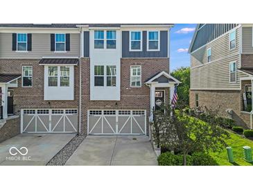 Charming townhome with a brick facade, two-car garage, and well-manicured landscaping at 16060 Barringer Ct, Westfield, IN 46074