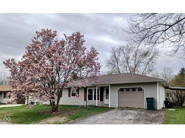 Charming ranch home with a beautiful flowering tree in the front yard and a single-car garage at 1706 Manor Dr, Lebanon, IN 46052