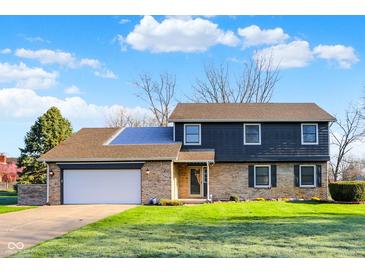 Charming two-story home with a brick facade, attached garage, and well-manicured lawn on a sunny day at 3771 Lakewood Dr, Greenfield, IN 46140