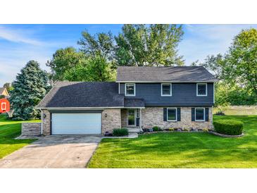 Charming two-story home with a brick and vinyl exterior, a well-manicured lawn, and an attached two-car garage at 3771 Lakewood Dr, Greenfield, IN 46140