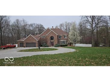 Elegant brick home featuring a circular driveway, mature trees, and a beautifully landscaped front yard at 4743 Little Hurricane Rd, Martinsville, IN 46151