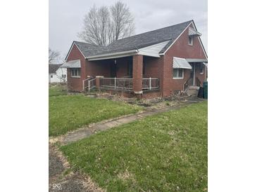 Charming one-story brick home featuring a covered front porch and classic architectural details at 6206 W Us Highway 40, Stilesville, IN 46180
