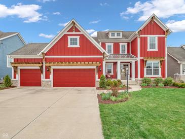 Charming red two-story home boasting a three-car garage and well-manicured lawn, perfect for curb appeal at 10603 Hinterland Dr, Fishers, IN 46038