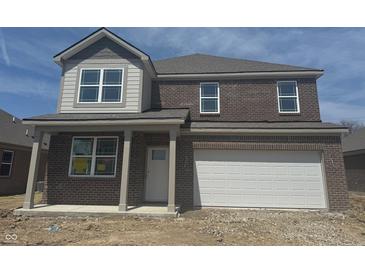 Two-story home with brick and siding, attached garage, and covered front porch on a sunny day at 1378 Foxtail Ln, Greenwood, IN 46143