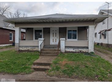 Charming single-story home featuring a covered front porch and a quaint yard at 1524 Ohio Ave, Anderson, IN 46016