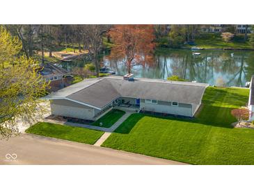 An aerial shot of a single story home with a large lawn and waterfront access on a sunny day at 315 Sunset Dr, Columbus, IN 47201