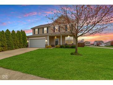 Charming two-story home with a well-manicured lawn and a lovely tree in the front yard at sunset at 3511 Limesprings Ln, Whitestown, IN 46075