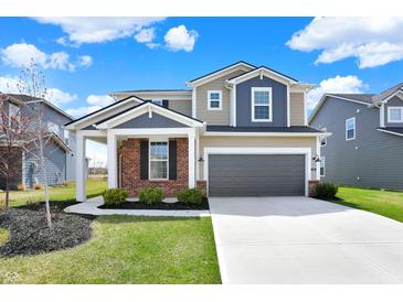 Beautiful two-story home featuring a two-car garage, landscaped yard, and a welcoming covered front porch at 4941 Oak Hill Dr, Lebanon, IN 46052