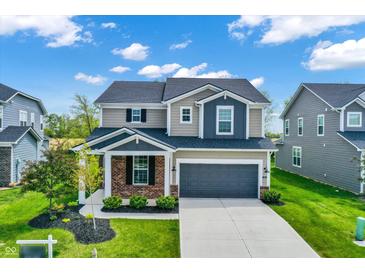 Charming two-story home featuring a well-maintained lawn, gray garage door, and a welcoming brick-accented porch at 4941 Oak Hill Dr, Lebanon, IN 46052