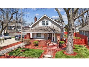 Charming two-story home with inviting brick porch and landscaped front yard at 5116 Norway Dr, Indianapolis, IN 46219