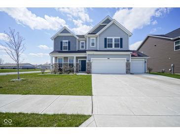 Charming two-story home featuring a well-manicured lawn and a spacious three-car garage at 7140 Leatherwood Dr, Indianapolis, IN 46259