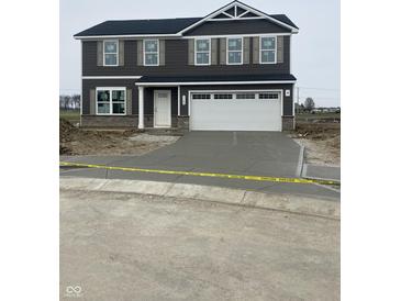 New two story home with gray siding, a white garage door, and professional landscaping at 7182 Finley Creek Dr, Whitestown, IN 46075