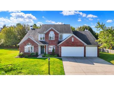 Charming brick home featuring a three-car garage and a well-manicured lawn at 10401 Monarch Ct, Noblesville, IN 46060