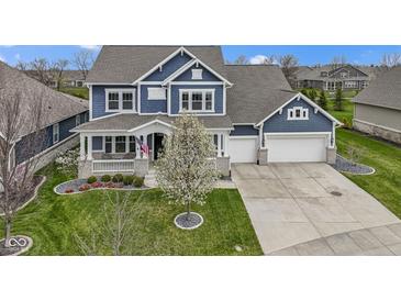 Beautiful two-story home boasting a two-car garage, covered porch, mature landscaping, and blue siding at 14918 Dawnhaven Dr, Westfield, IN 46074