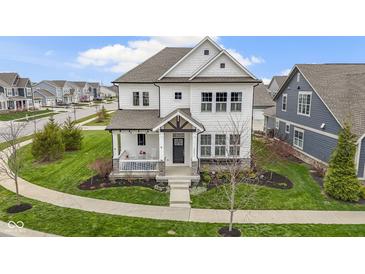 Beautiful two-story home boasting a charming front porch, manicured lawn, and modern architectural design at 15591 Heatherbank Dr, Westfield, IN 46074